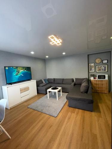 a living room with a couch and a flat screen tv at Like a home Linda Apartment in Narva