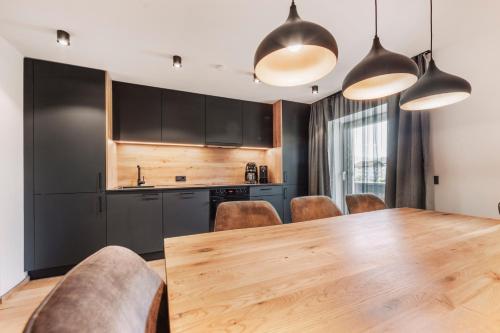 a kitchen and dining room with a wooden table and chairs at Apart Walser in Seefeld in Tirol