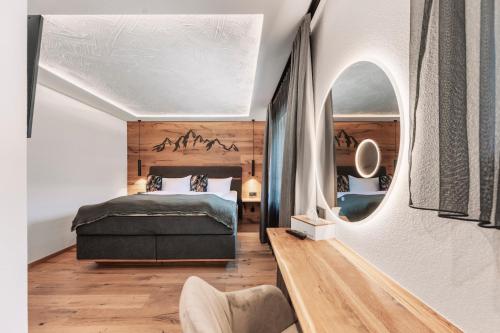 a bedroom with a bed and a mirror at Apart Walser in Seefeld in Tirol