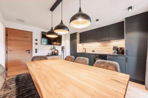 a kitchen and dining room with a wooden table and chairs at Apart Walser in Seefeld in Tirol