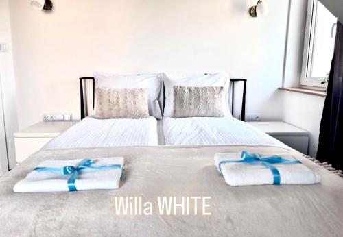 a white bed with two towels on top of it at Dom Michałki Luksusowa willa z ogrodem in Michalki
