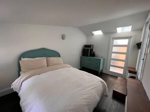 a bedroom with a bed with a green headboard and a window at Unique private room and bath in Halifax