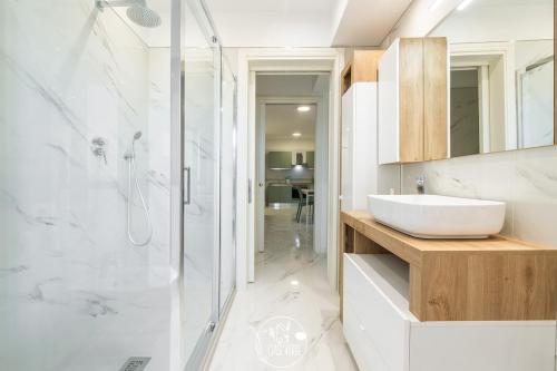 a white bathroom with a sink and a shower at L' Oasi Verde in Pirri