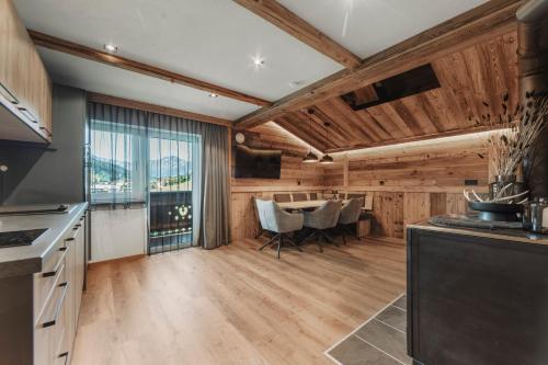 a kitchen with wooden walls and a table with chairs at Apart Walser in Seefeld in Tirol