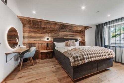 a bedroom with a large bed and a wooden wall at Apart Walser in Seefeld in Tirol