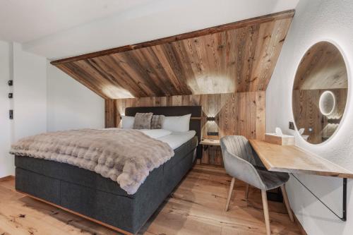 a bedroom with a bed and a desk with a chair at Apart Walser in Seefeld in Tirol