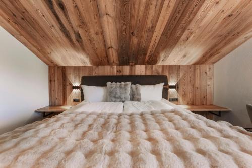 a bedroom with a large bed with a wooden ceiling at Apart Walser in Seefeld in Tirol