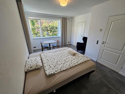 a bedroom with a bed and a table and a window at Lovely room near train&airport in Copenhagen