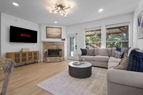 a living room with a couch and a fireplace at Heated Pool & Spa Mini Golf Bowling Game Room perfect for family in Rockwall