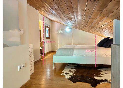 a bedroom with a bed and a wooden ceiling at Dúplex con Parking en el Corazón de Incles I AndBnB HUT17488 in Canillo