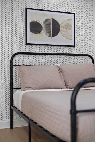 a bed in a bedroom with a picture on the wall at Heated Pool & Spa Mini Golf Bowling Game Room perfect for family in Rockwall