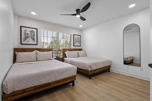 a bedroom with two beds and a ceiling fan at Heated Pool & Spa Mini Golf Bowling Game Room perfect for family in Rockwall