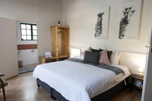 a bedroom with a large white bed with pillows at Koo Karoo Guest Lodge and Self Catering in Montagu