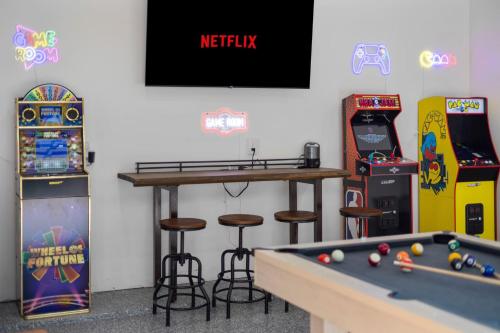 a room with a pool table and arcade games at Heated Pool & Spa Mini Golf Bowling Game Room perfect for family in Rockwall