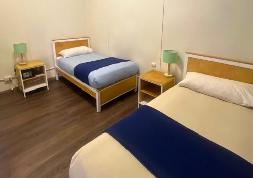 a hotel room with two beds and two lamps at The Hostel Santiago in Santiago