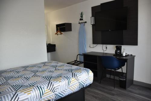 a bedroom with a bed and a desk and a tv at Studio 6-Grand Prairie, TX in Grand Prairie