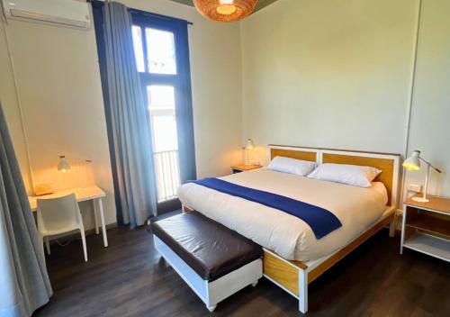 a bedroom with a bed and a large window at The Hostel Santiago in Santiago