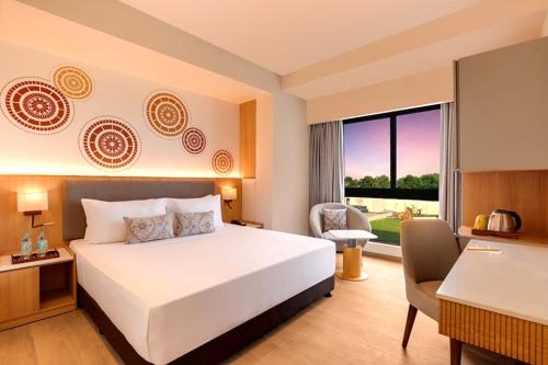 a hotel room with a bed and a desk and a window at Hotel Tela Suite plaza A Family Hotel- Delhi Airport Free Airport Drop in New Delhi