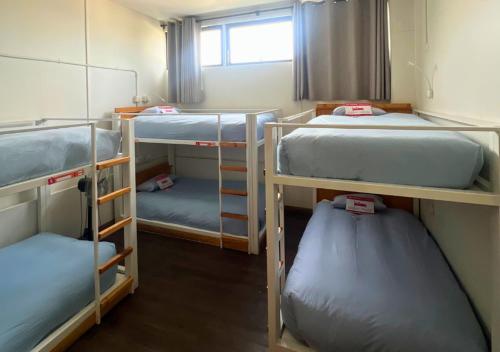 a room with three bunk beds and a window at The Hostel Santiago in Santiago