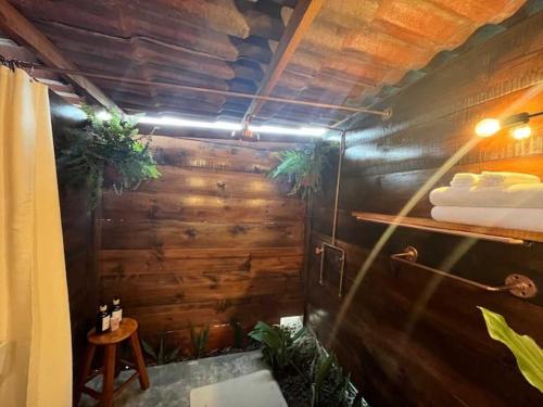 a bathroom with a wooden wall with plants in it at Glamping Rincón de Lavanda in Texcoco de Mora