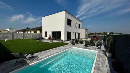 a swimming pool in front of a white house at Exkluzívny rodinný dom Trnava - rodiny, pracovné cesty in Trnava