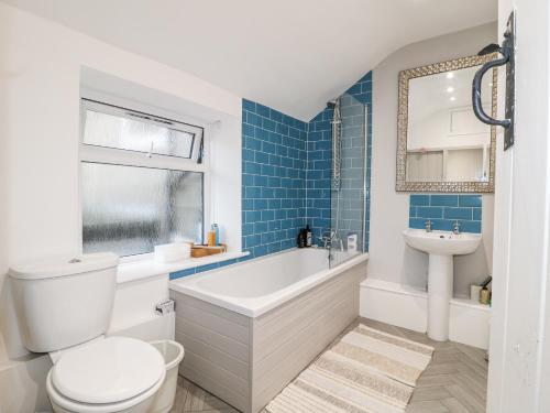 a bathroom with a tub and a toilet and a sink at 5 Belper Lane End in Belper