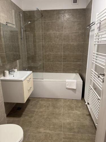 a bathroom with a tub and a toilet and a sink at Daiana Apartament in Timişoara