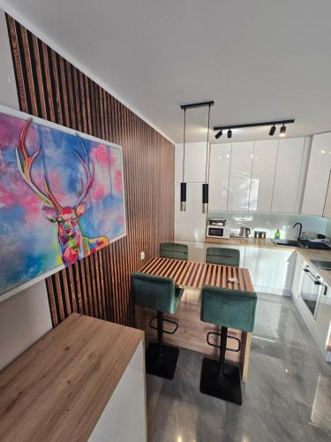 a kitchen with a table and a painting of a deer at Apartament Cysterska 18/24 in Wągrowiec