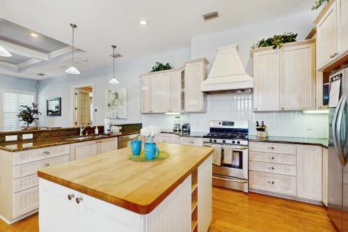 a kitchen with white cabinets and a wooden counter top at Coastal Oasis in Largo
