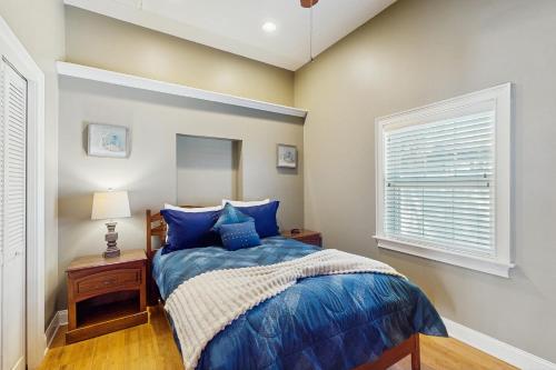 a bedroom with a blue bed and a window at Coastal Oasis in Largo