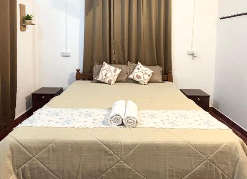 a bedroom with a large bed with two towels on it at Serendipity Goa - Apartments and Cafe in Arambol