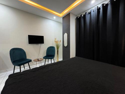 a bedroom with two chairs and a bed and a tv at Furnished Apartment Islamabad in Islamabad