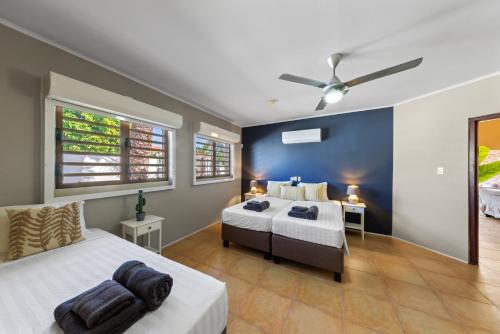 a bedroom with two beds and a ceiling fan at Villa CuraSea in Jan Thiel