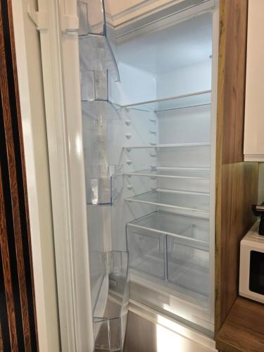 a refrigerator with clear glass shelves in it at Apartament Cysterska 18/24 in Wągrowiec