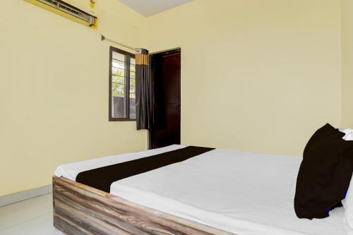 a white bed in a room with a window at HOTEL O SOURYA RESIDENCY in Sānkchi