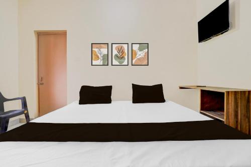 a bedroom with a white bed and a tv at HOTEL O SOURYA RESIDENCY in Sānkchi