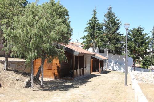 una casa de madera con árboles delante de ella en Douro Camping, en Miranda do Douro