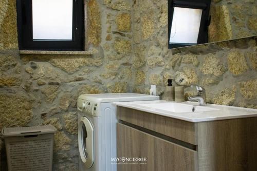 a bathroom with a sink and a washing machine at Quinta Dos Sonhos in Vale de Cambra