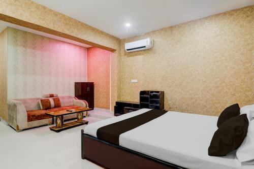 a bedroom with a bed and a couch at HOTEL O YASH RAJ PALACE in Rāe Bareli