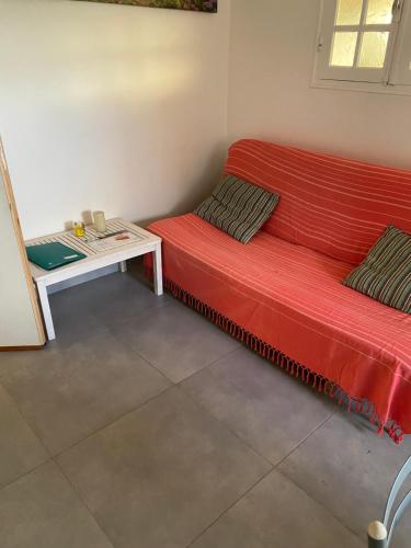 Sofá rojo en una habitación con mesa en Gwada vacances, en Sainte-Rose