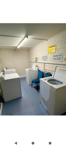 a room with two toilets and two blue chairs at The lighthouse in Leysdown-on-Sea