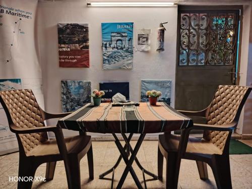 a wooden table with two chairs in a room at بيت الطبيعة nature house in Jerash