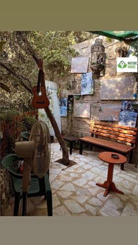 a patio with a bench and a fan and a table at بيت الطبيعة nature house in Jerash