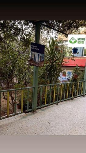 a sign on a pole next to a fence at بيت الطبيعة nature house in Jerash