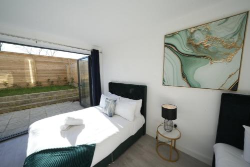 a bedroom with a bed and a large window at Ealing Broadway Great Stay 7-Minute Walk from the Underground in Ealing