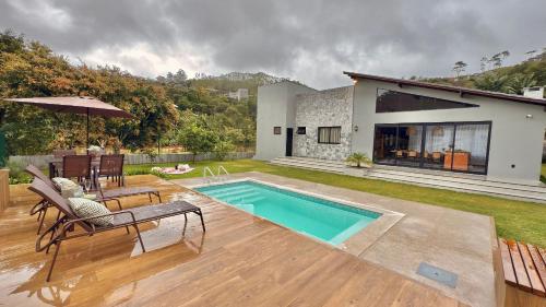 ein Hinterhof mit einem Swimmingpool und einem Haus in der Unterkunft Casa Morada do Lago in Santa Maria
