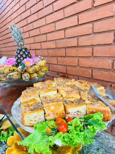 a bunch of food on a table next to a brick wall at Hotel Garnier in Campos do Jordão