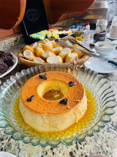 a cake on a glass plate on a table at Hotel Garnier in Campos do Jordão