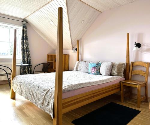 a bedroom with a bed with a wooden frame at Lake View Apartment at North Lakeside Villa Plateliai in Medsėdžių