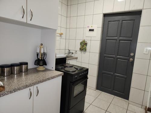 a kitchen with a stove and a black door at Busa House in White River